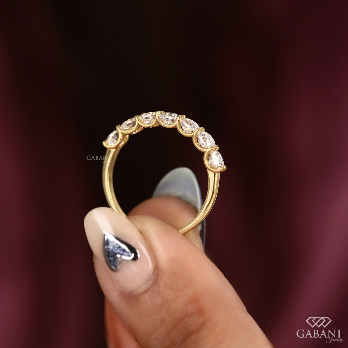 slim yellow gold band featuring seven cushion cut lab created diamonds in a u prong setting