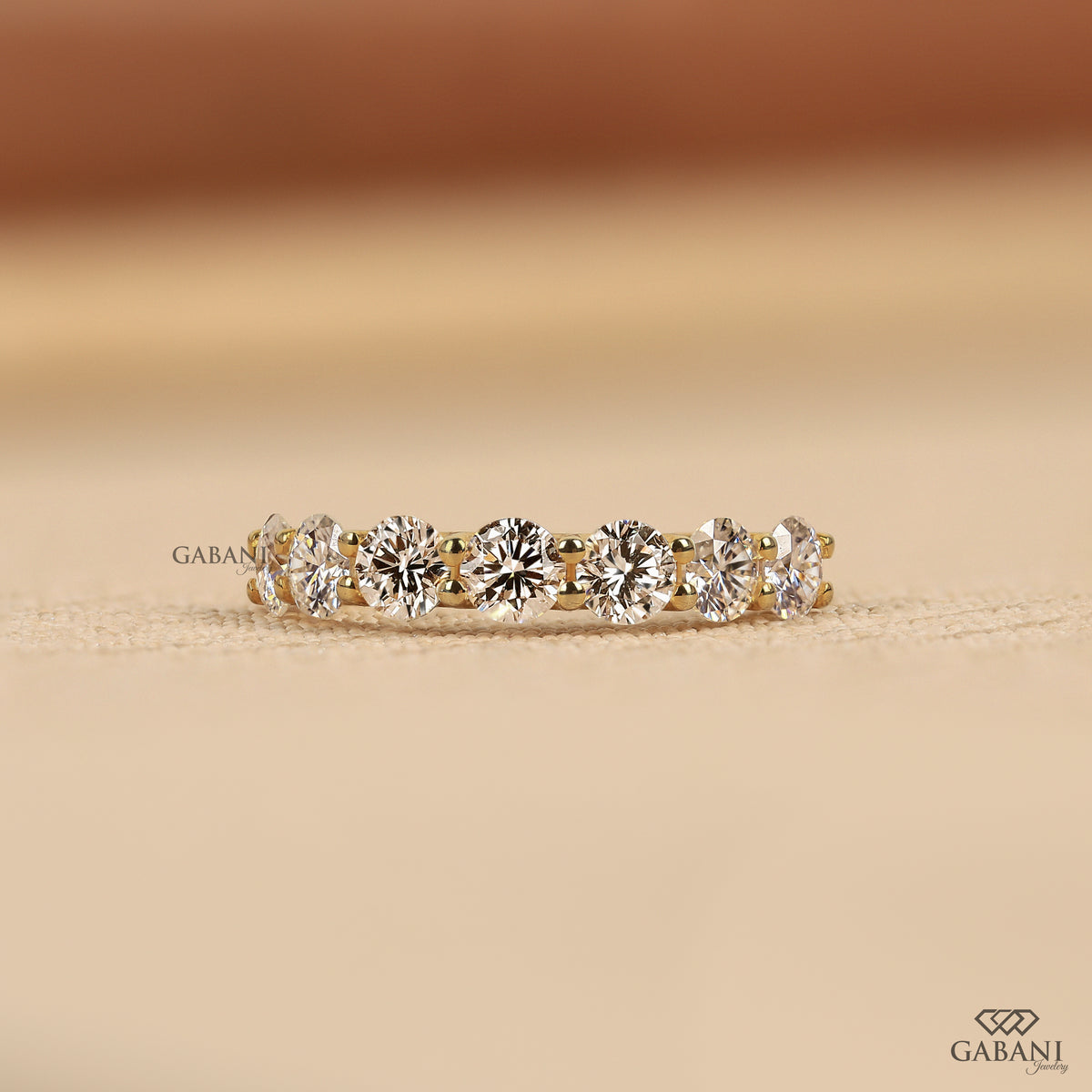 7 stone lab grown diamond wedding band with round cut diamonds in a U prong setting crafted in 14k yellow gold