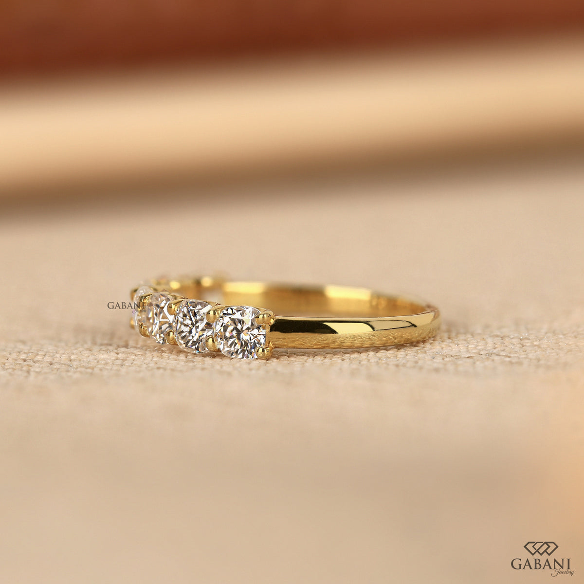 seven cushion cut lab created diamonds set across a yellow gold comfort fit band