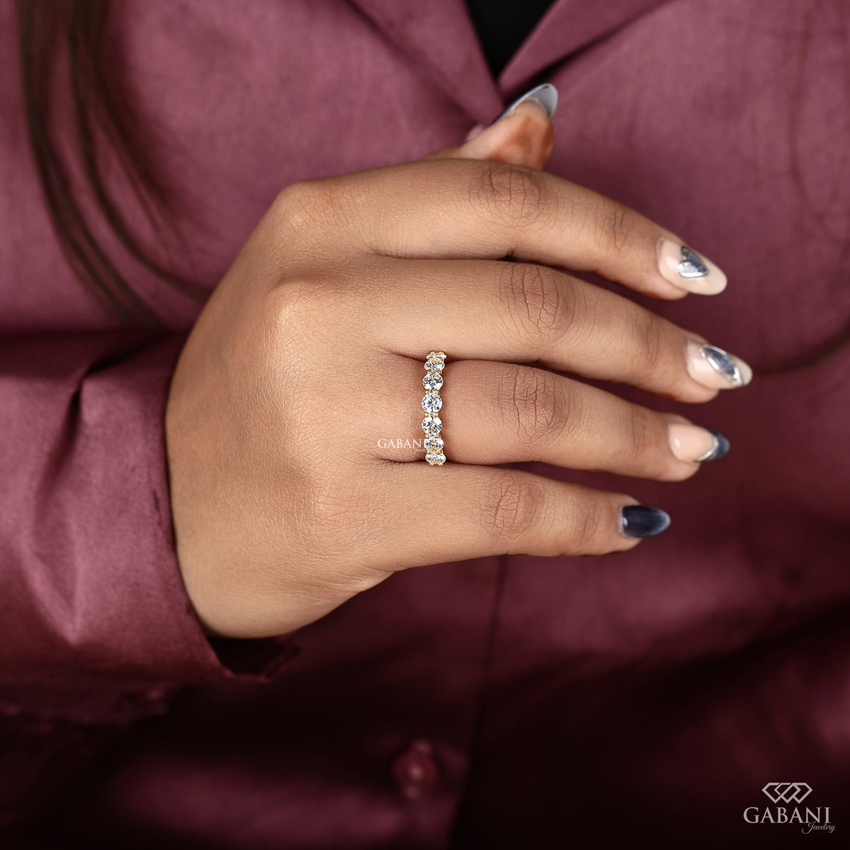 round cut lab grown diamond wedding band with seven stones and a slim yellow gold band