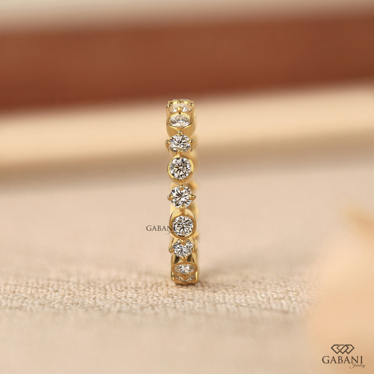 certified lab grown diamond wedding band with round stones in a bezel set eternity style