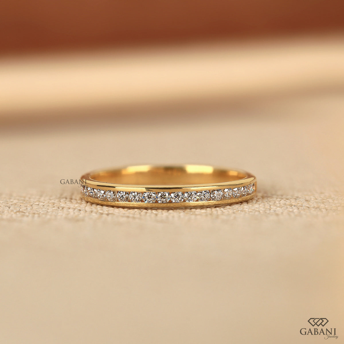 thin yellow gold band with channel set lab grown diamonds in a minimal half eternity design