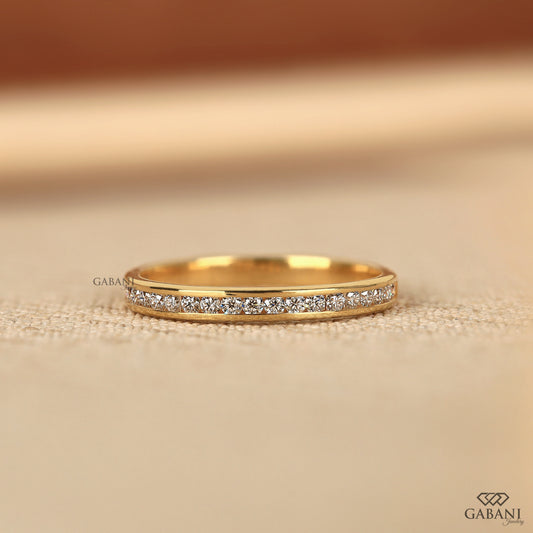 thin yellow gold band with channel set lab grown diamonds in a minimal half eternity design