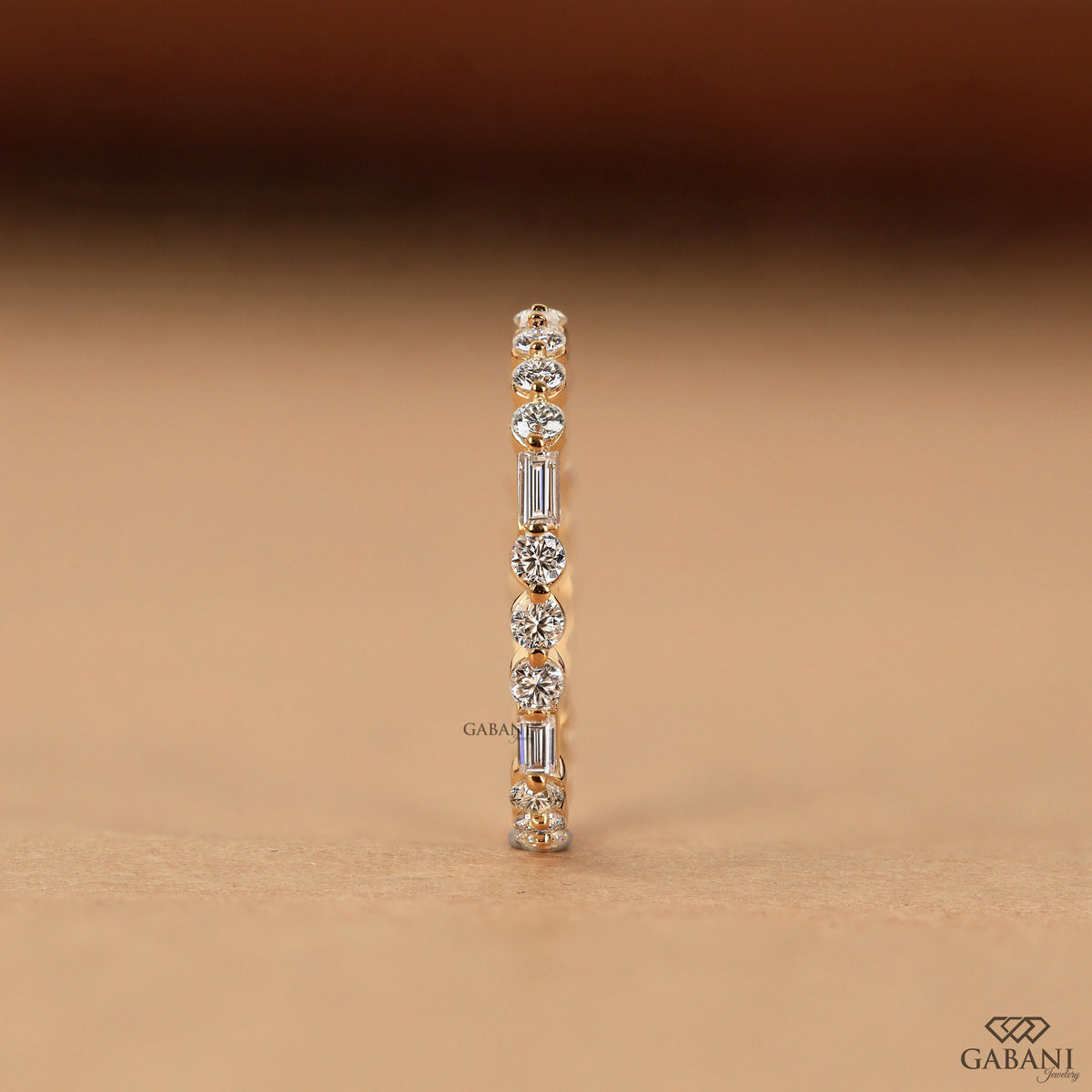 thin lab grown diamond wedding band with baguette and round stones in gold