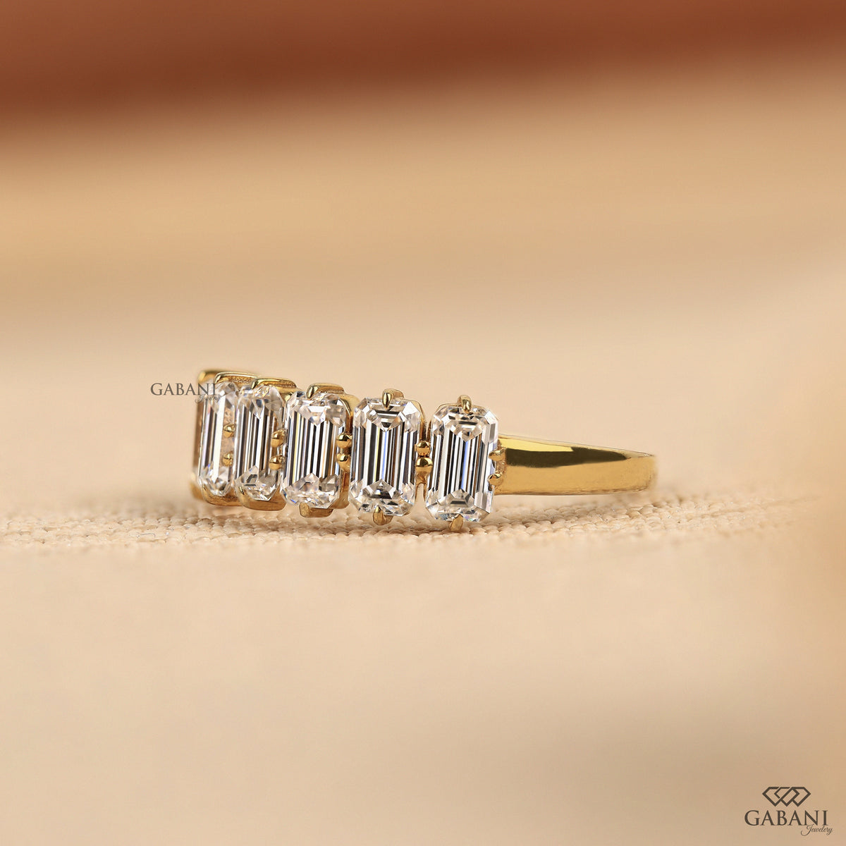 Seven diamond ring with emerald cut lab grown stones set in a refined yellow gold band