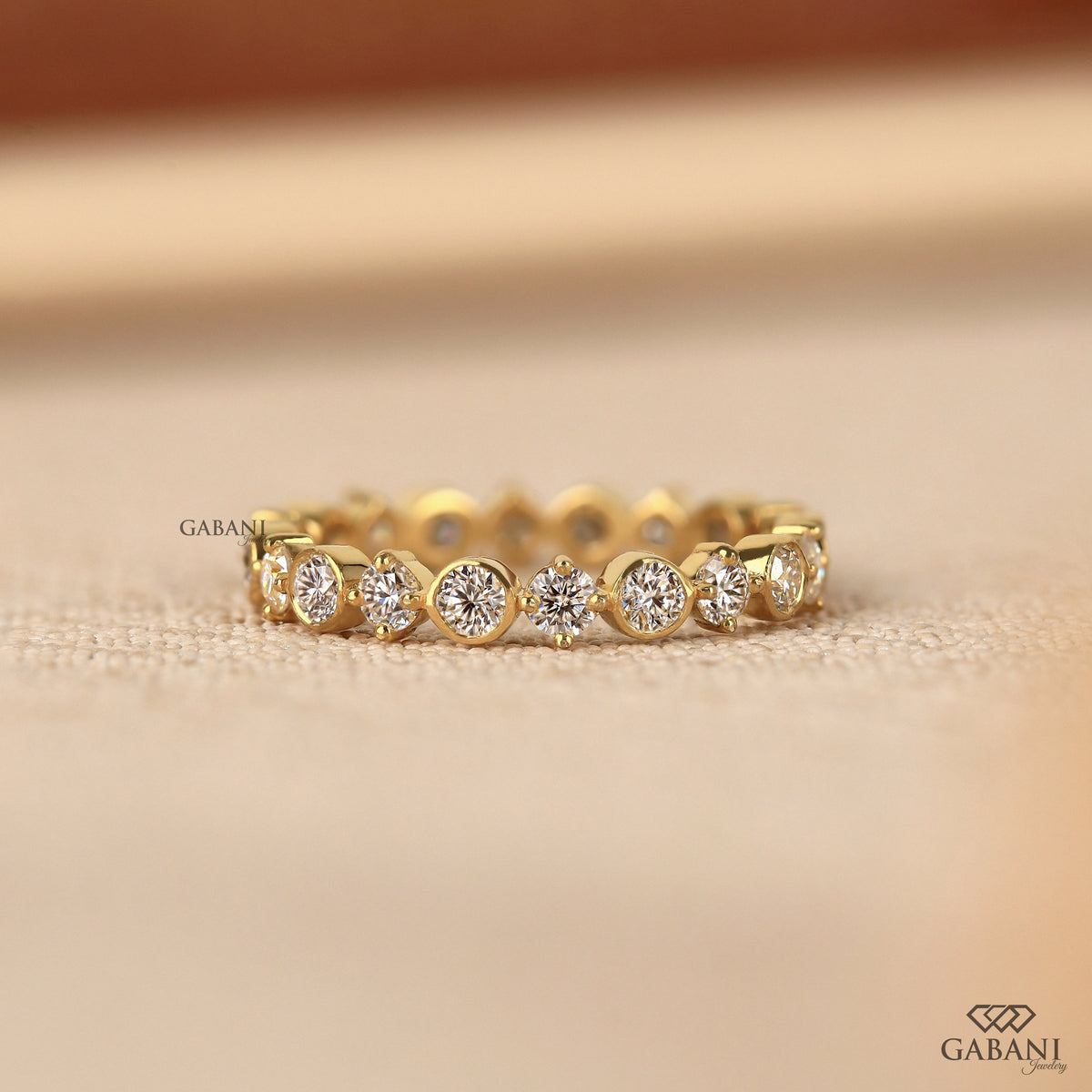 bezel set round lab grown diamond wedding band in 14k yellow gold with full eternity design and smooth polished finish