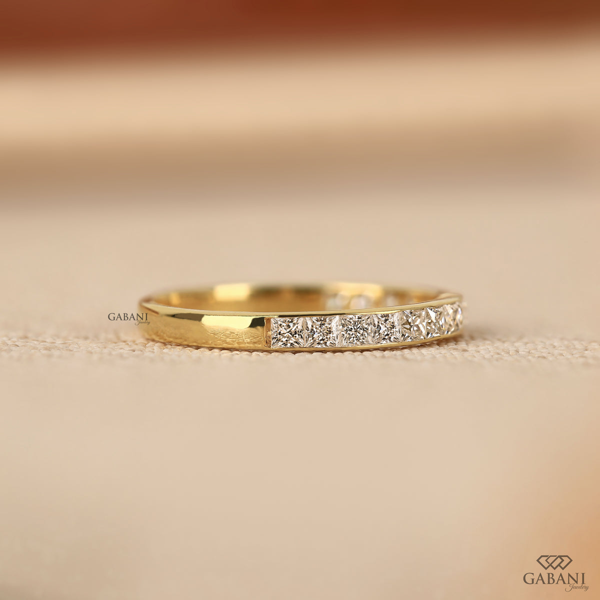 yellow gold channel set wedding band with princess cut lab grown diamonds and smooth edges