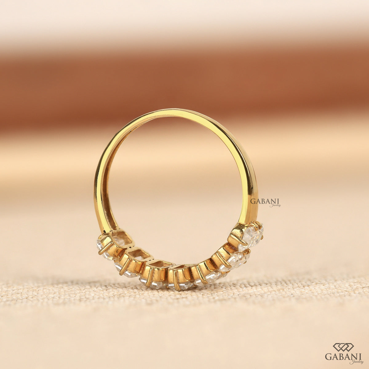Comfort fit yellow gold band featuring seven emerald cut lab grown diamonds in half eternity style