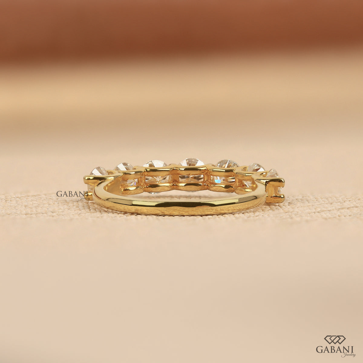 yellow gold wedding band featuring seven round cut lab grown diamonds in a U prong setting