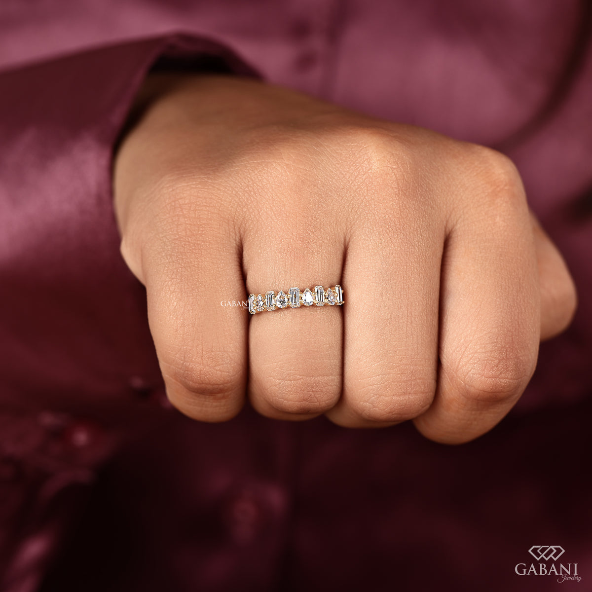 stackable lab grown diamond wedding band with emerald and pear shapes in yellow gold
