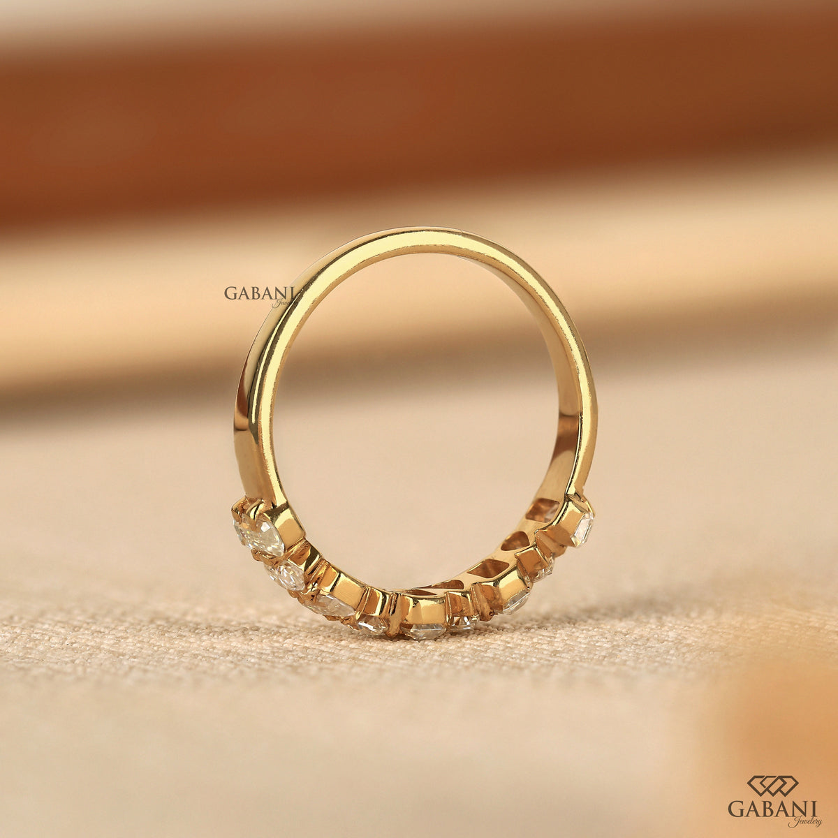 handcrafted yellow gold band with emerald and pear cut lab created diamonds