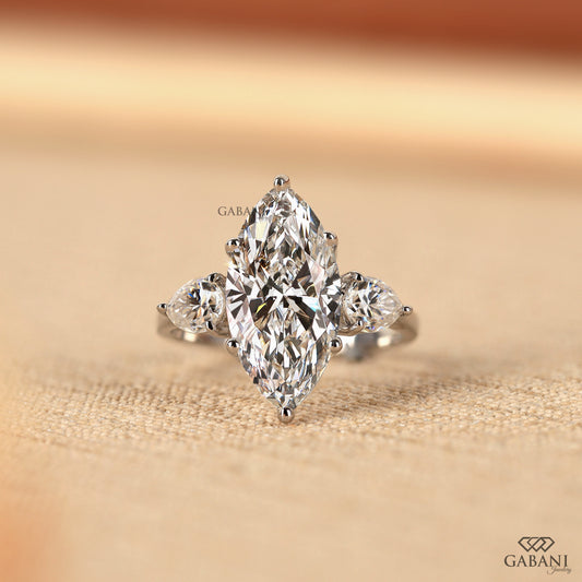 Three stone lab grown diamond engagement ring with marquise center and pear side stones in solid 18K white gold