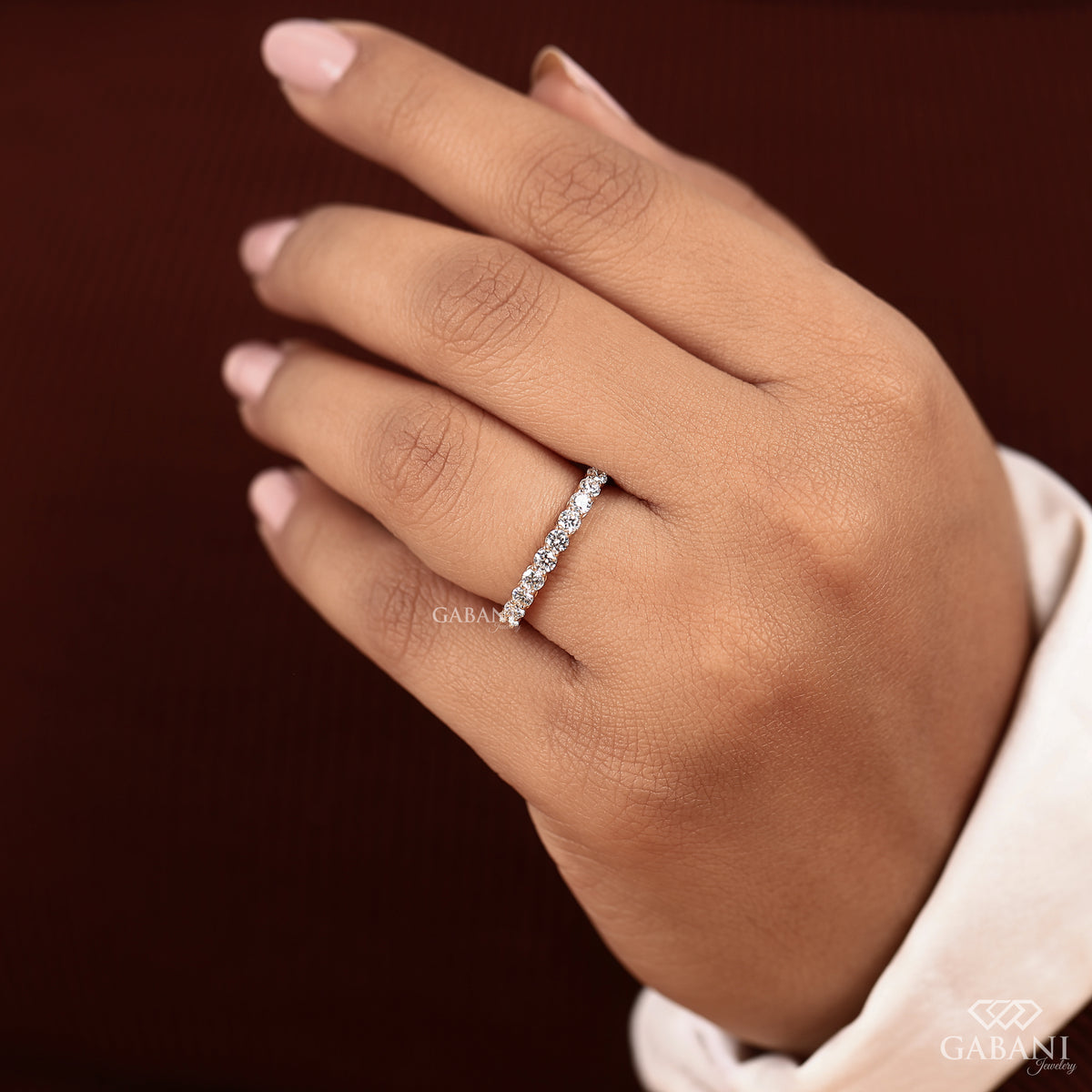 Minimal round lab grown diamond wedding band with shared prong setting in yellow gold