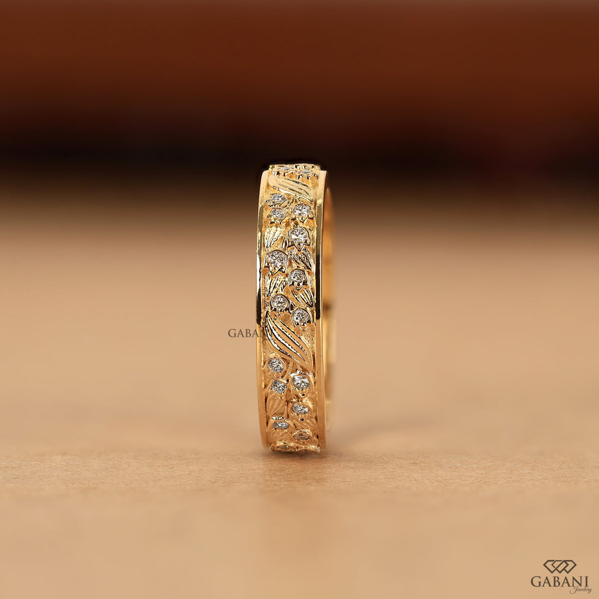 gabani jewelry yellow gold wedding band with detailed leaf design and smooth interior