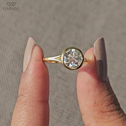 Round cut lab grown diamond solitaire ring in yellow gold bezel setting