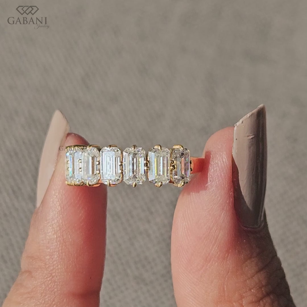 Emerald cut lab grown diamond band with seven stones in compass setting crafted in yellow gold