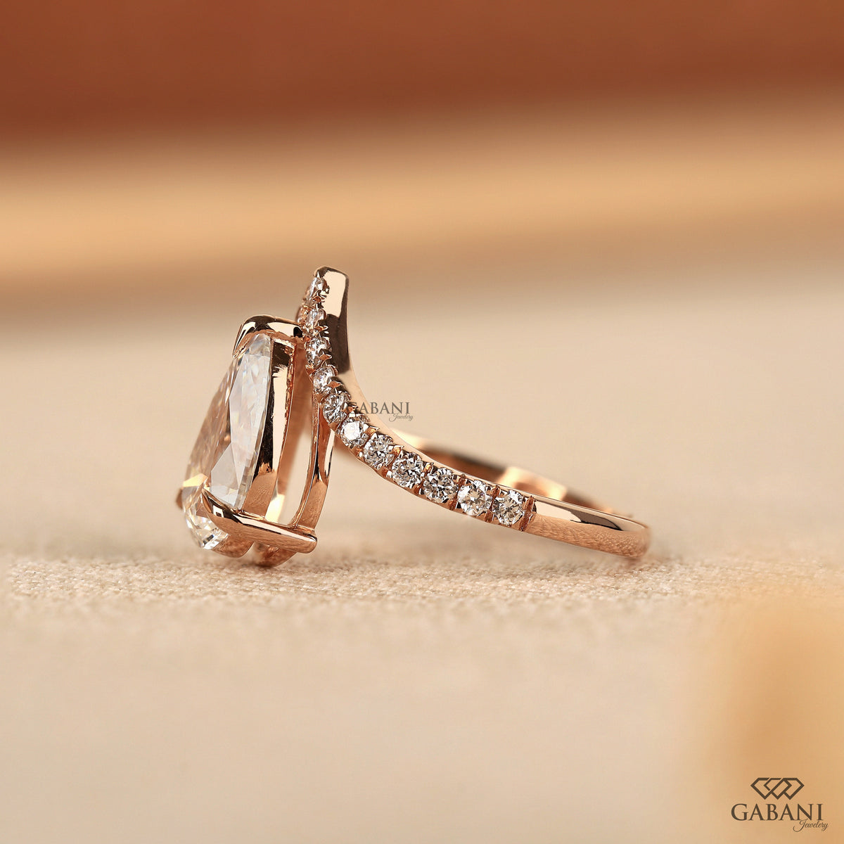 Claw prong pear cut diamond ring with pavé round stones