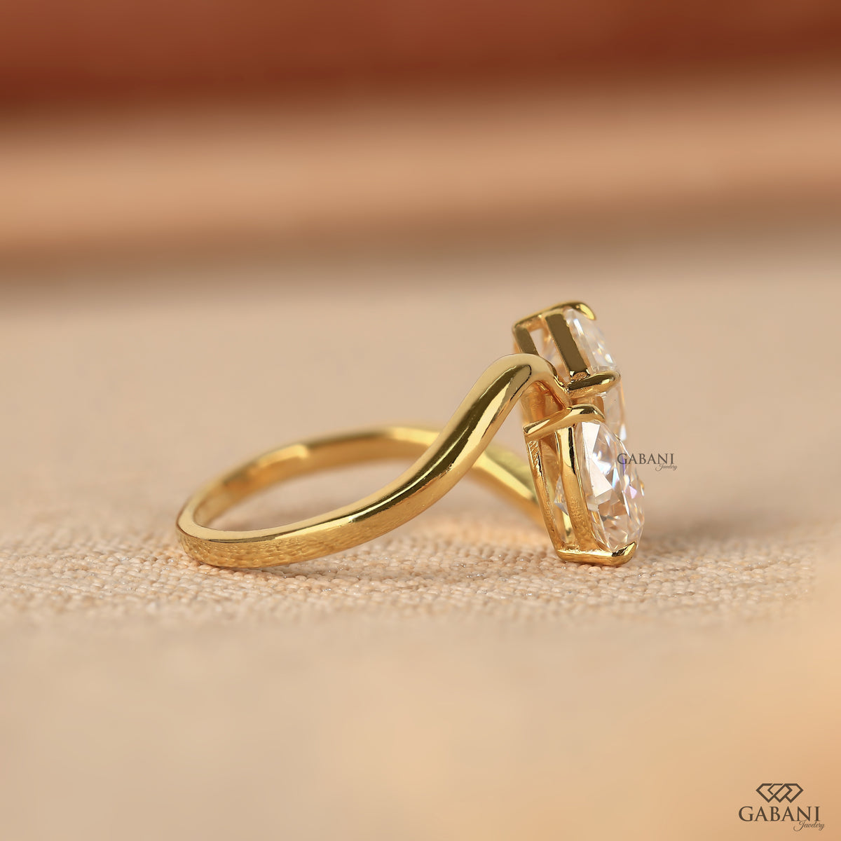 toi et moi ring with emerald and pear shaped lab grown diamonds and cross band design