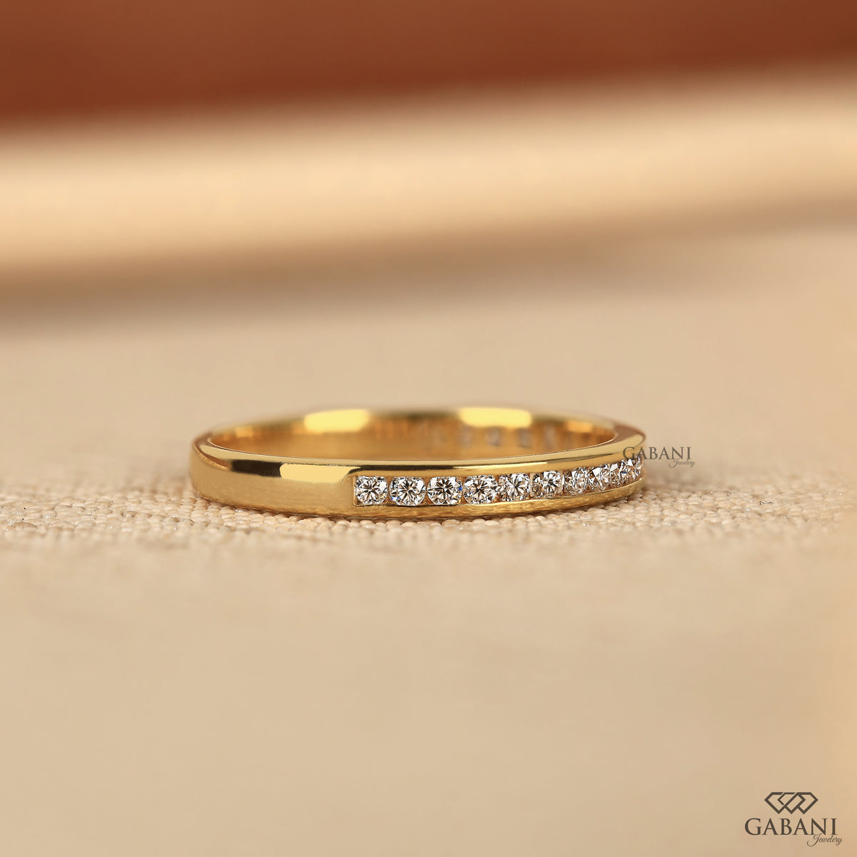 minimal yellow gold diamond band designed with a smooth channel setting